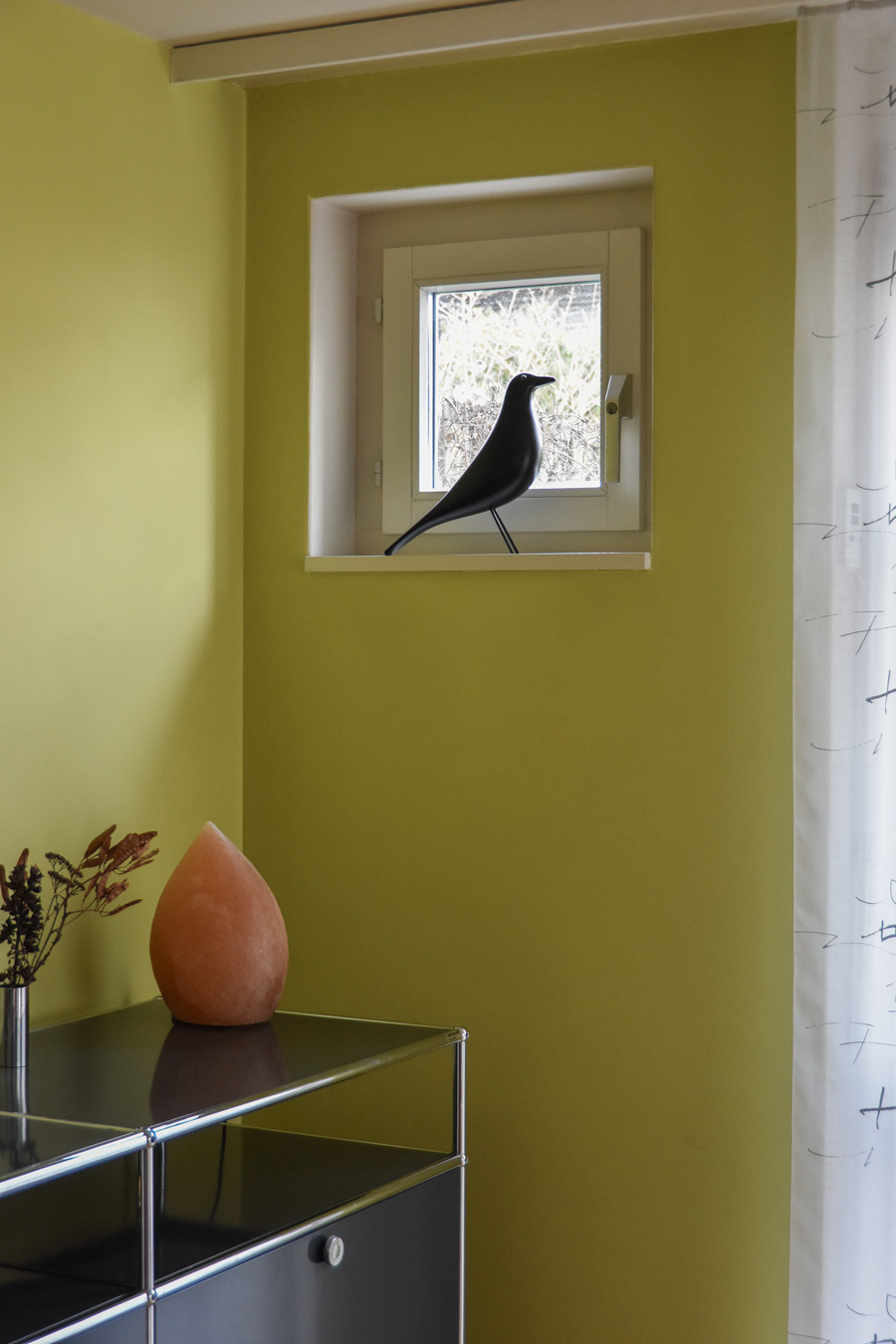 Farbgestaltung + Feng Shui im Innenraum: Das Bild zeigt einen Ausschnit des Esszimmers im Erdgeschoss mit einem kleinen Fenster, in frühlingshaftem Grün.