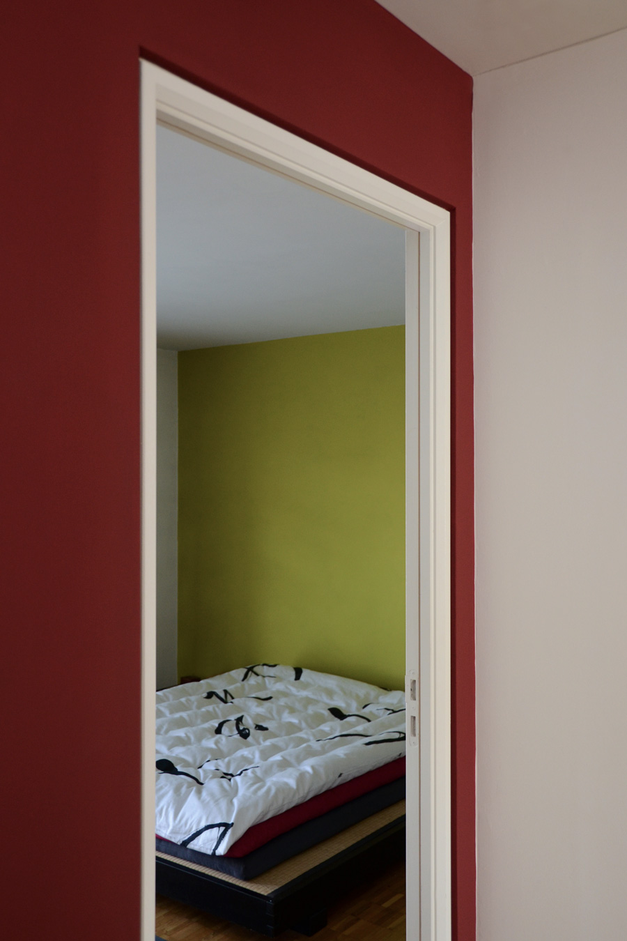 Farbgestaltung + Feng Shui im Innenraum: Das Bild zeigt das Schlafzimmer im Obergeschoss mit Rückwand in Olivgrün.