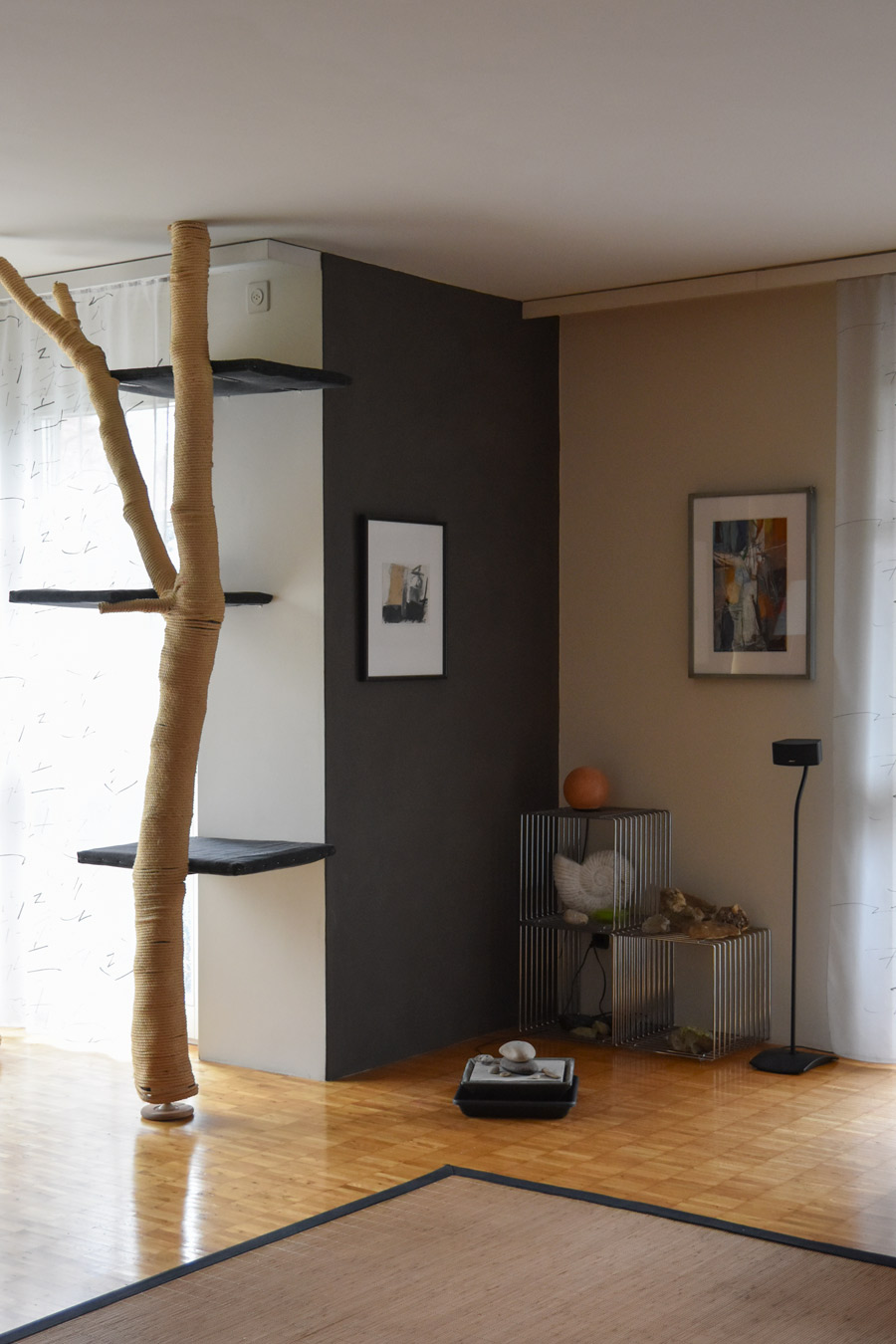 Farbgestaltung + Feng Shui im Innenraum: Das Bild zeigt das Wohnzimmer im Erdgeschoss in hellem Sandton mit graubrauner Eckwand.