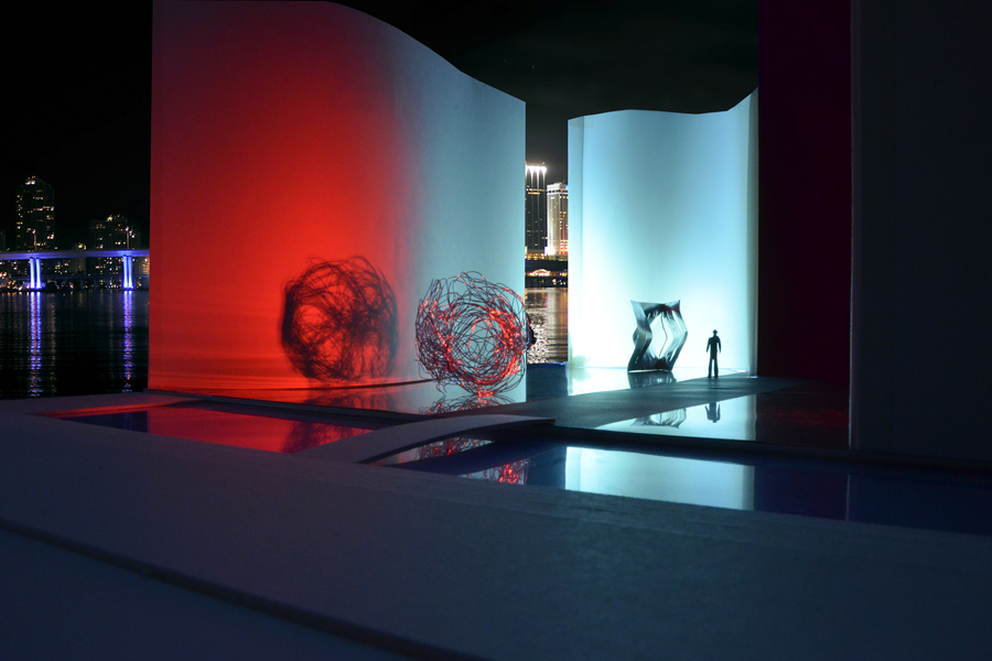 Farbe + Licht: Das Bild zeigt den Skulpturenhof im farbigem Kunstlicht bei Nacht, vor stästischer Kulisse.