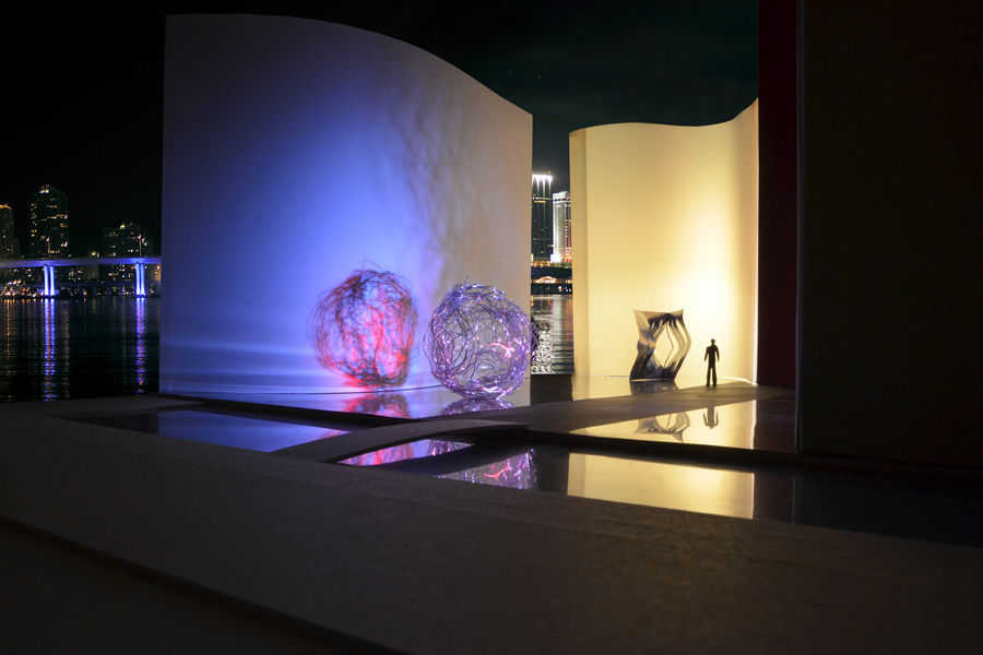 Farbe + Licht: Das Bild zeigt den Skulpturenhof im farbigem Kunstlicht bei Nacht, vor stästischer Kulisse.