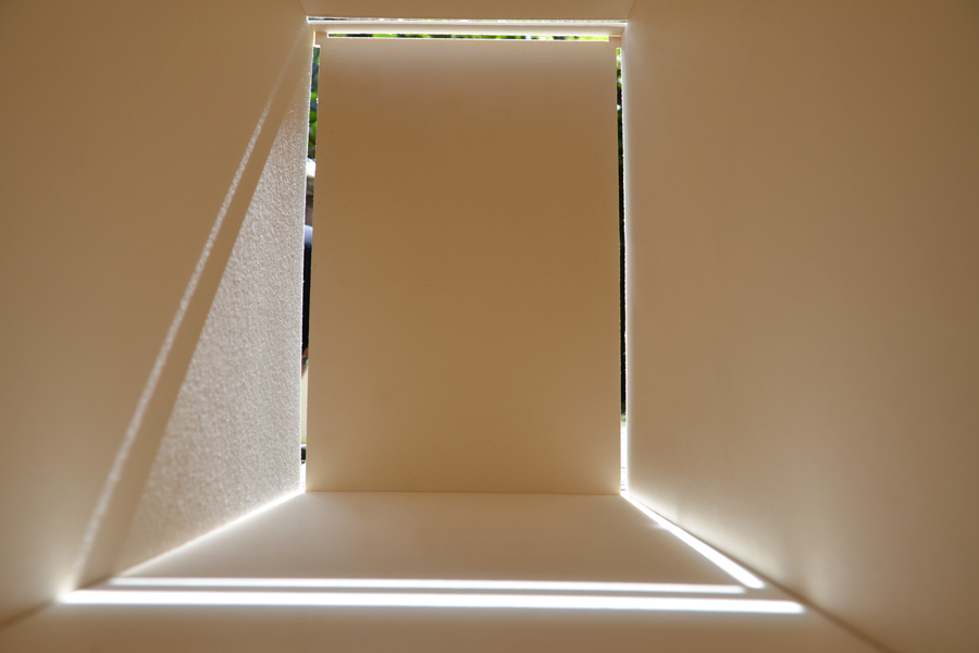 Farbe + Licht: Das Bild zeigt die Wirkung von Tageslicht durch vertikale und horizontale Öffnungen in das Innere eines kleinen Raummodells aus Karton.