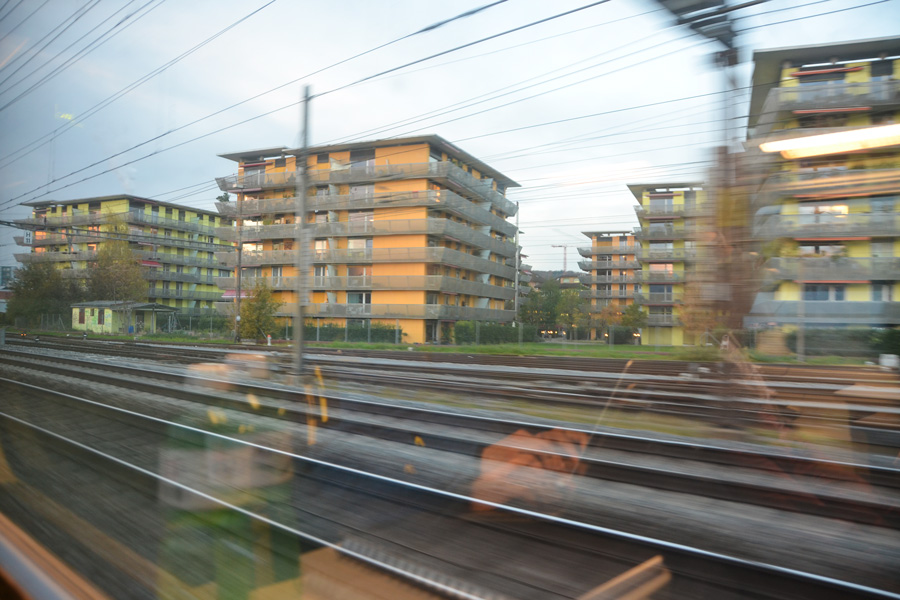 Farbgestaltung im Aussenraum: Das Bild zeigt die Sicht aus dem Zug auf die Wohnsiedlung Röntgenareal vom Zug aus bei der Ausfahrt aus dem Zürcher Hauptbahnhof.