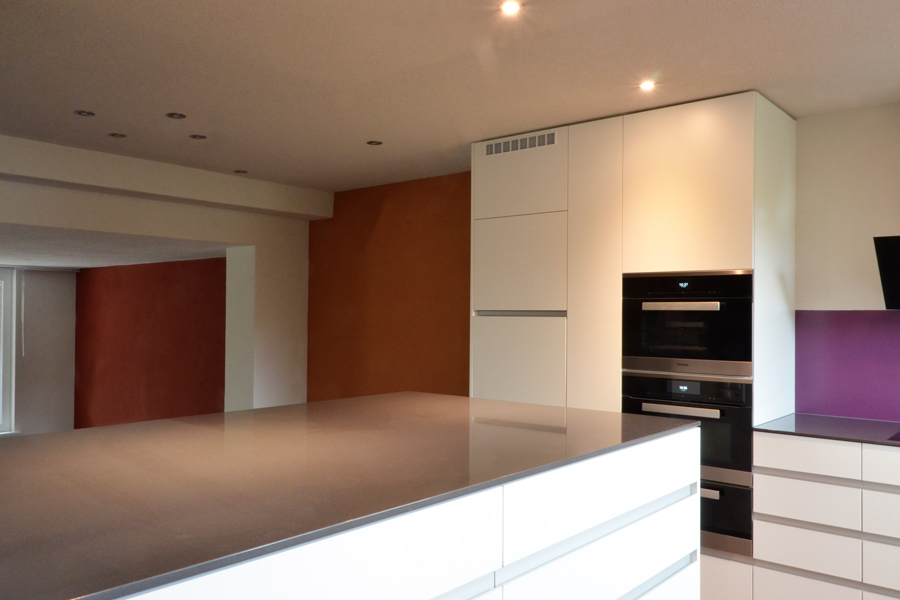 Farbgestaltung Wohnraum: Das Bild zeigt den Blick durch die offene Küche zum Ess- und Wohnbereich nach der Renovation.