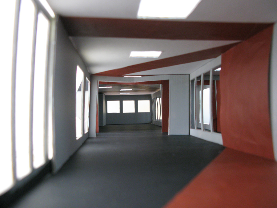 Farbkonzept im öffentlichen Raum: Das Bild zeigt das Raummodell der Mittelstation Gotschna mit der Farbgestaltung mit Rot als Linien über Boden, Wände und Decken - Modellfotografie Innenraum.
