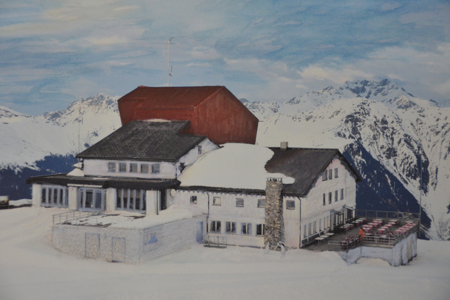 Farbkonzept im öffentlichen Raum: Die Visualisierung (eine zeichnerisch und malerisch bearbeitete Fotografie) zeigt die äussere Farbgestaltung der Bergstation der Seilbahn Gotschna, Klosters.