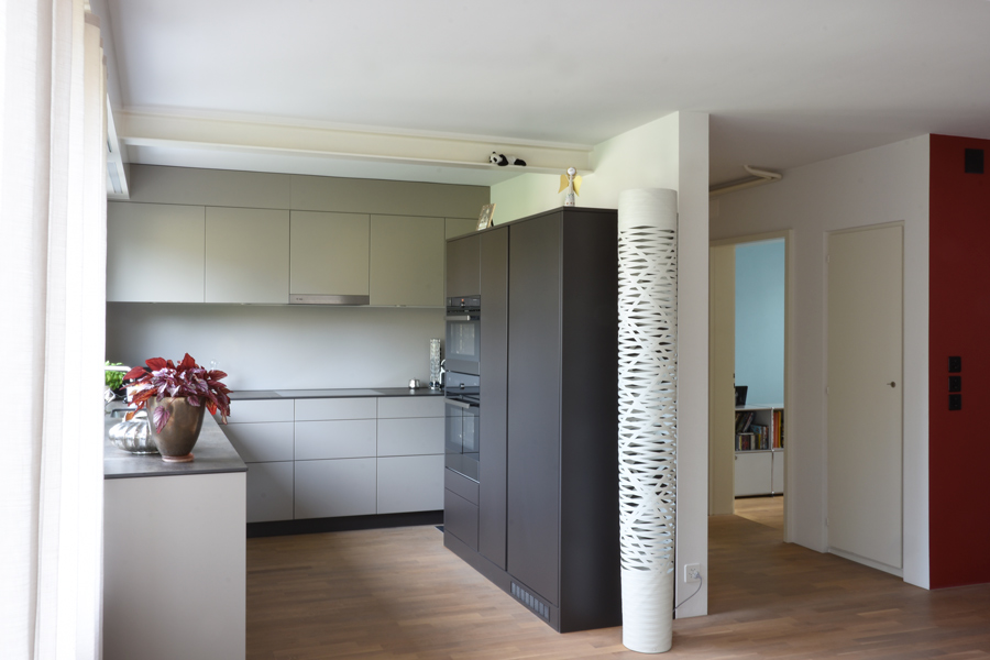 Farbgestaltung Innenraum: Das Bild zeigt den Blick vom Essbereich in die offene Küche und zum Gang.