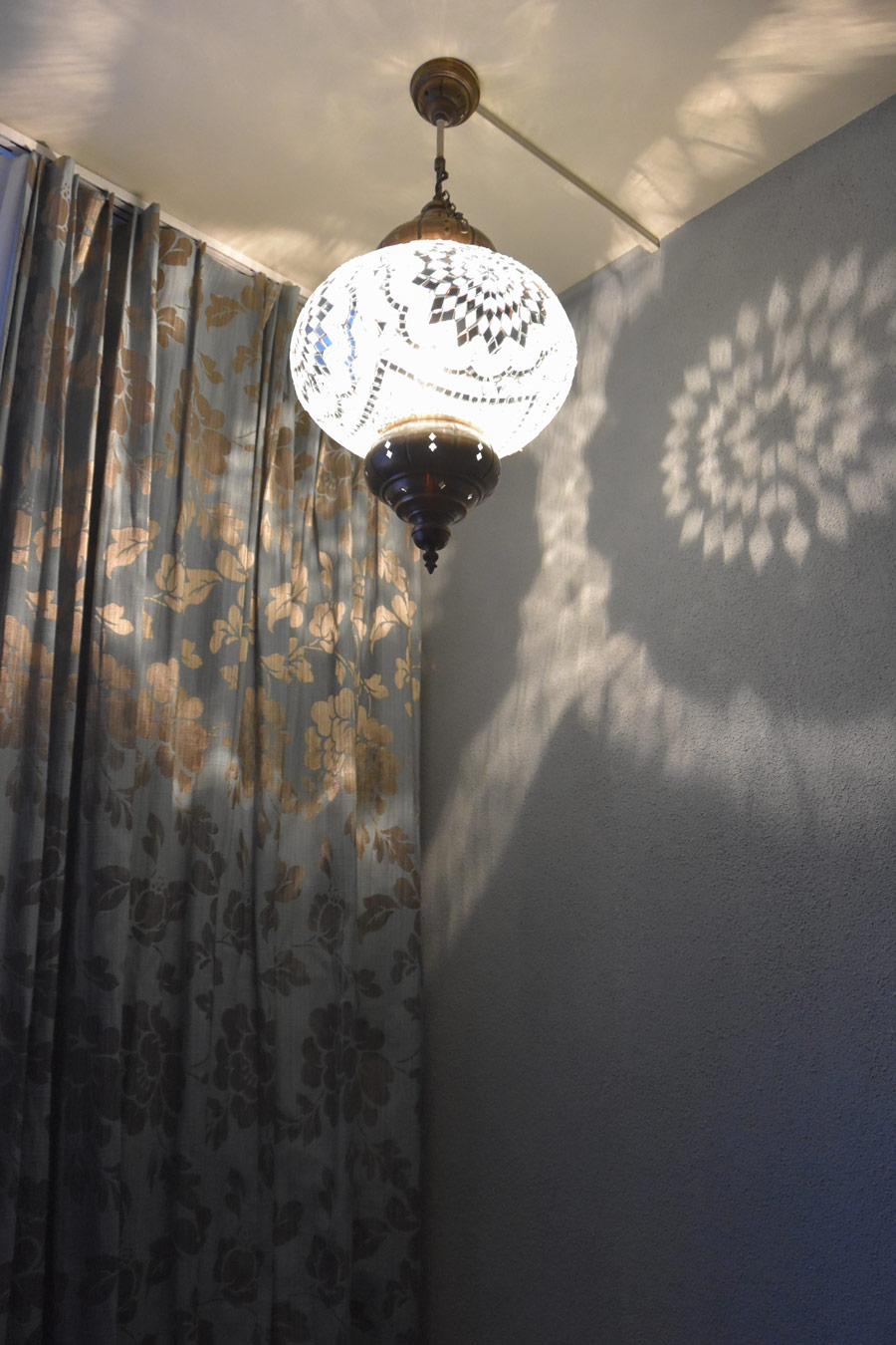 Farbgestaltung Elternschlafzimmer: Das Bild zeigt das durch eine orientalische Leuchte erzeugte Lichtspiel auf dem Vorhang und auf der Wand.