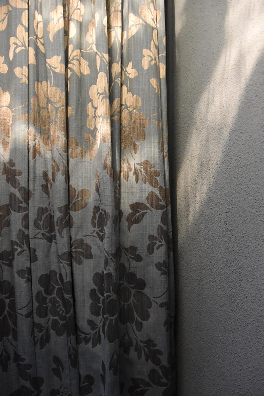Farbgestaltung Elternschlafzimmer: Das Bild zeigt ein Detail des Vorhangs und das Spiel des Lichts, das sich auf dem Stoff spiegelt.