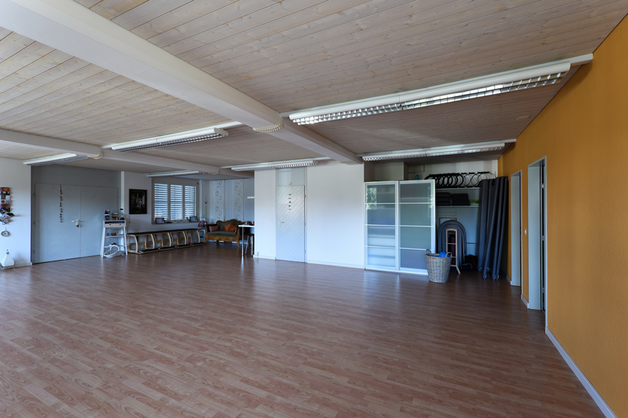 Farbgestaltung Gesundheitsraum Yoga + Pilates: Das Bild zeigt den Blick in den grossen Gruppenraum diagonal in Richtung Eingangsbereich.
