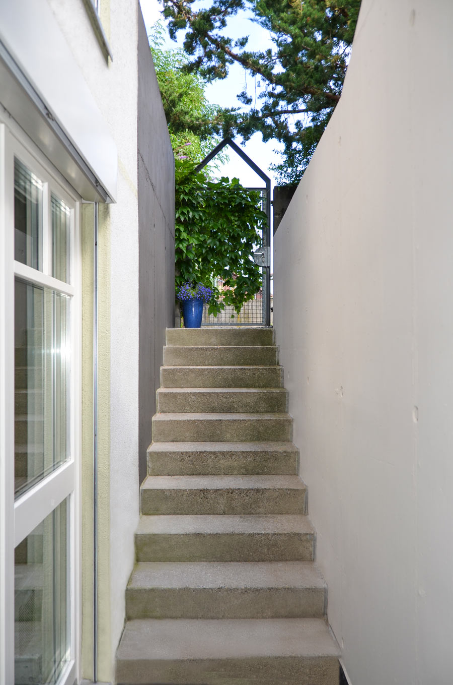 Farbgestaltung im Aussenraum: Das Bild zeigt den Blick von der Haustür zum Gartentor hoch.