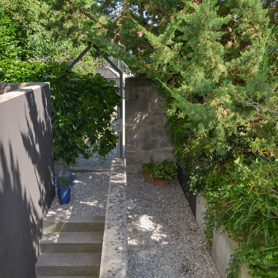 Farbgestaltung im Aussenraum: Das Bild zeigt den Blick vom Gartenbereich zurück zum Eingangsbereich mit dem Gartentor.