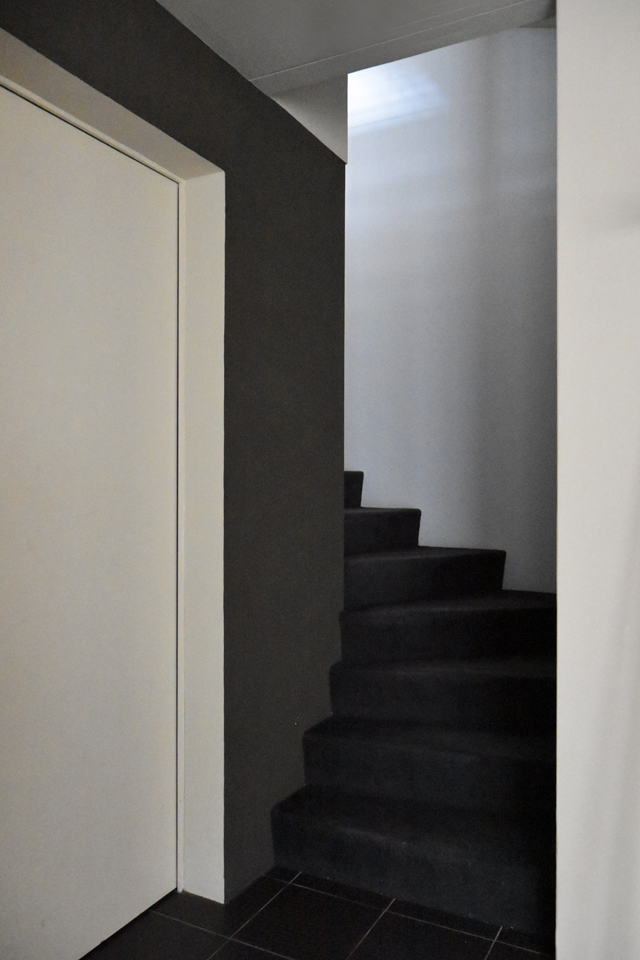 Farbgestaltung + Feng Shui im Innenraum: Das Bild zeigt das Treppenhaus zum Erdgeschoss, das ein Helldunkel-Kontrast zwischen linker Wand in Graubraun und rechter Wand in hellem Lapislazuliblau zeigt.